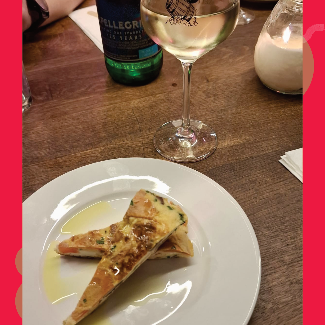 Weinglas und kleiner Teller mit herzhaftem Fingerfood als Begleitung zu einer Rebenreise Mosel Weinprobe in der Weinlounge Zell.