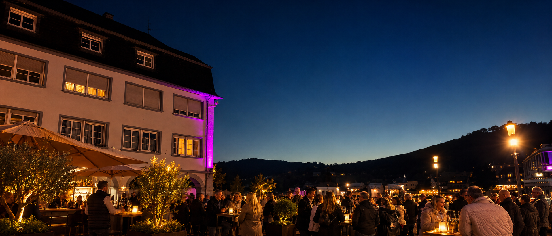 Stimmungsvolle Weinlounge in Zell an der Mosel bei Nacht mit warmem Licht, Schirmen, Gästen, Wein und entspannter Atmosphäre auf dem Marktplatz vor der Moselkulisse.